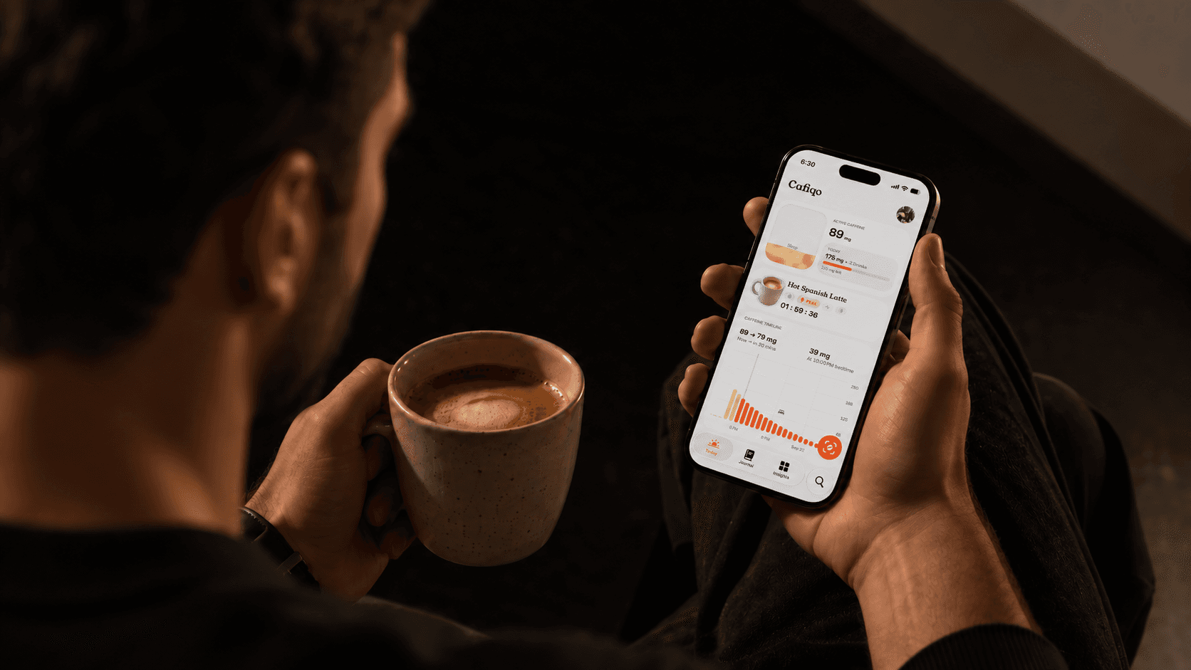 A person holding coffee while checking Cafiqo on an iPhone